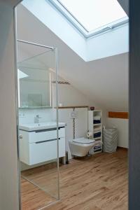 a bathroom with a tub and a sink and a mirror at Ferienhaus Am Weitfeld - Ruheoase mit Garten & Bergblick nahe Salzburg in Ainring