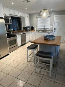 a kitchen with a island with two stools in it at Lagniappe Retreat in Long Beach