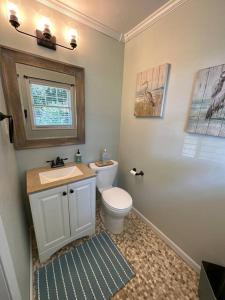 a bathroom with a toilet and a sink and a window at Lagniappe Retreat in Long Beach +35 photos