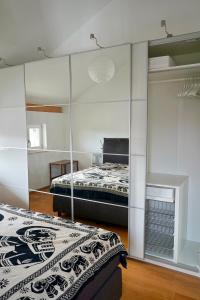 a bedroom with two beds and a mirrored wall at Ferienhaus Am Weitfeld - Ruheoase mit Garten & Bergblick nahe Salzburg in Ainring