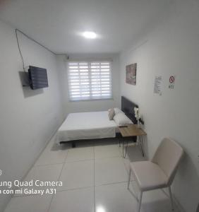 a bedroom with a bed and a desk and a chair at Hotel Avei Suites in Cali +15 photos