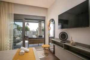 a living room with a television and a couch at Maro Luxury Villa in Afantou