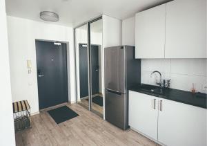 a kitchen with white cabinets and a stainless steel refrigerator at Apartment with a large balcony in Vilnius