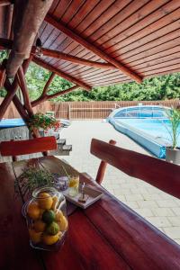 a table with a bowl of fruit on top of a patio at Harmónia Kulcsosház Ivó in Siculeni