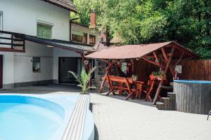 a patio with a table and a pavilion next to a house at Harmónia Kulcsosház Ivó in Siculeni