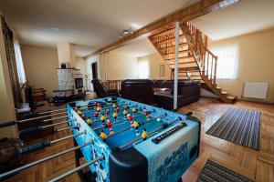a living room with a foosball table in the middle at Harmónia Kulcsosház Ivó in Siculeni