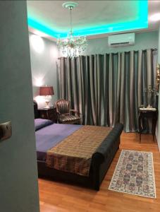 a bedroom with a large bed and a chandelier at Balcony With A View in Nafplio