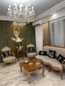 a living room with two couches and a chandelier at Balcony With A View in Nafplio