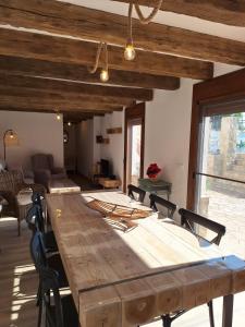 a large wooden table in a room with chairs at La Palmera Casa Rural in L'Aldea