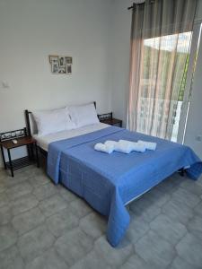 a bedroom with a bed with two towels on it at Deco Apartments Aigina in Vaia