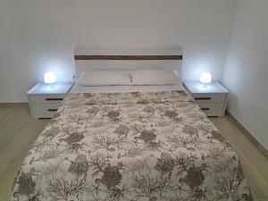 a bedroom with a bed with two nightstands at Casa Vacanze Argento in Bacoli