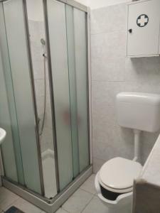 a bathroom with a toilet and a glass shower at "HOUSE OF LELLA 2" appartamento 1 camera da letto - M1 METRO ROSSA in Milan +12 photos