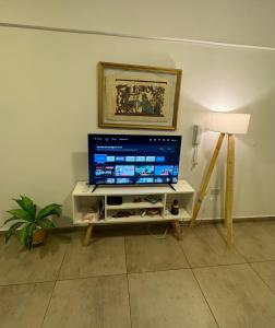a living room with a flat screen tv on a stand at Hermoso y completo departamento centrico in La Rioja