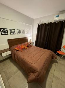 a bedroom with a large bed with a brown comforter at Hermoso y completo departamento centrico in La Rioja