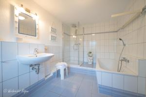 a bathroom with a sink and a tub and a toilet at Ferienhaus Luppath in Poseritz +25 photos