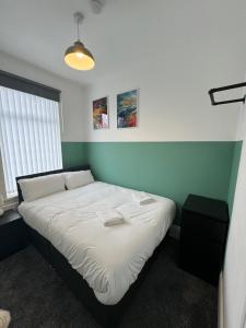 a bedroom with a bed in a room with green walls at Luna Apartments Newcastle Gateshead 1 in Gateshead