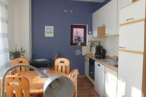 a kitchen with a wooden table and a blue wall at Ferienwohnung Jehn in Fulda