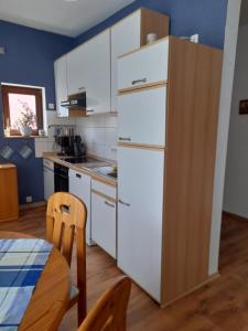 a kitchen with a white refrigerator and a table at Ferienwohnung Jehn in Fulda