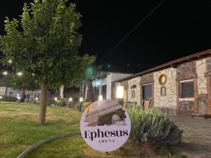 a sign in front of a building at night at Erdem Ciftligi/ Ephesus Arena in Selçuk