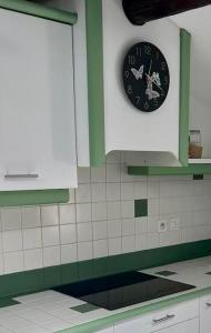 eine Uhr an der Wand über einer Küchentheke in der Unterkunft Studio Cosy au Coeur de Narbonne in Narbonne