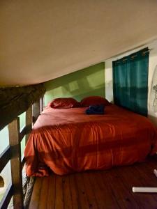 Schlafzimmer mit einem Bett mit einer roten Bettdecke in der Unterkunft Studio Cosy au Coeur de Narbonne in Narbonne