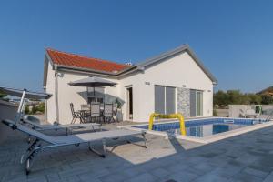 a house with a swimming pool and a patio at Villa Nicolle in Privlaka
