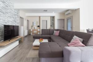 a living room with a couch and a television at Villa Nicolle in Privlaka