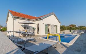 a villa with a swimming pool and a house at Villa Nicolle in Privlaka
