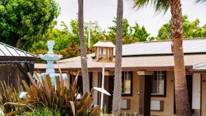 a house with palm trees in front of it at Americas Best Value Inn, Antioch in Antioch