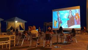 a group of people sitting in chairs in front of a screen at Batumi-Gonio Mgzavrebi Apartmant in Gonio +22 photos