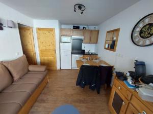 Forest des BaniolsにあるOrcières Location By JL - Pied des Pistes - Piscineのソファとキッチンのあるリビングルーム