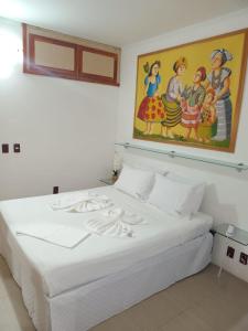 a white bed in a room with a painting on the wall at Flat, Hotel Imperial Suites - Recife in Recife
