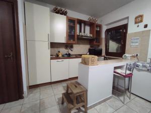 a kitchen with white cabinets and a white refrigerator at Green House in Rocca di Botte