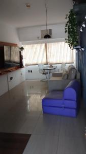a living room with a blue couch and a table at Flat, Hotel Imperial Suites - Recife in Recife