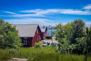 a red barn with a car parked next to a house at Villa Granit Studio Apartment in Hanko in Hanko