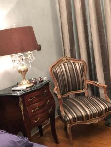 a bedroom with a chair and a lamp and a dresser at Balcony With A View in Nafplio