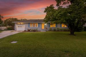 a blue house with a tree in the yard at Peace of Happiness Coastal Cottage 7 mi from Wrightsville Beach, NC in Windemere