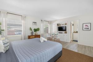 a white bedroom with a bed and a dining room at St Pete Boho Getaway Walk to Pier and Beach in St. Petersburg