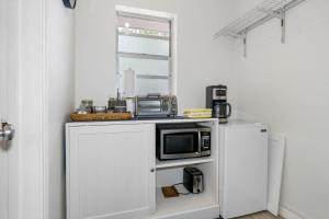 a kitchen with a microwave on a white refrigerator at St Pete Boho Getaway Walk to Pier and Beach in St. Petersburg