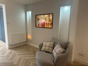 una sala de estar con una silla y una foto en la pared en Luxury Modern Spacious House, en Hull