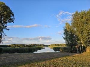 a picnic table next to a lake with a sky at Sīvera Medniekkrasti in Stoli