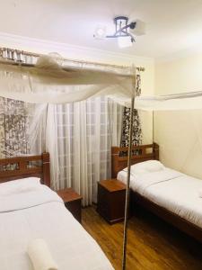 a bedroom with two beds and a canopy bed at Tevody Heights in Nairobi