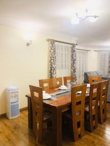 a dining room with a wooden table and chairs at Tevody Heights in Nairobi +16 photos
