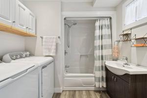 a white bathroom with a shower and a sink at Chalet Astra in Mandeville +6 photos