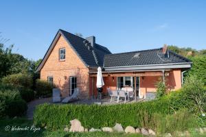 a brick house with a patio and a table and chairs at Ferienhaus Luppath in Poseritz