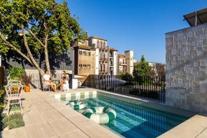 une piscine avec deux personnes assises à côté d'un bâtiment dans l'établissement Luxury Old Town Oasis for Family and Friends (Daily Breakfast + Housekeeping incl), à Porto