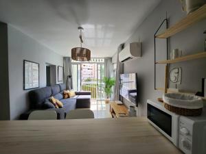 a living room with a blue couch and a tv at Apartamento Almar PLAYA DE LEVANTE in Benidorm
