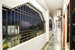 a corridor of a building with windows with black bars at Hotel O Shree Ram Residency in Cuttack