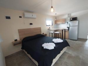 a bedroom with a bed with two towels on it at Apart Deluxe in Mina Clavero