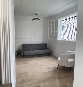 Una sala de estar con un sofá y una ventana. en Appartement avec jardin C, en Nogent-sur-Marne